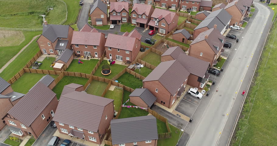 4K Aerial of new build development British housing estate. UK houses and homes in England. Drone footage over the top of countryside buildings. 