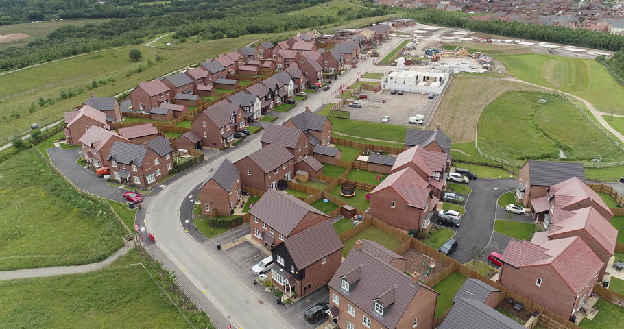 4K Aerial of new build development British housing estate. UK houses and homes in England. Drone footage over the top of countryside buildings. 