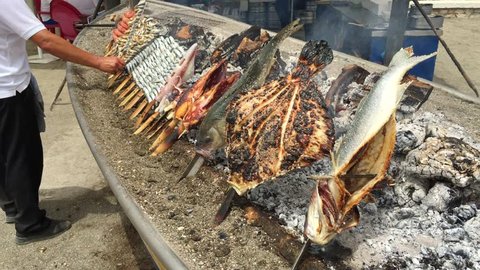 Sardine, shrimp, squid on sticks on fire are fried in a boat. Typical "espetos" food of Spain, Costa del Sol, Malaga. Traditional food.