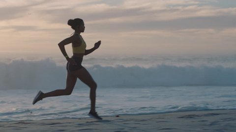 young woman athlete running on beach exercising female runner sprinting training in evening seaside background sunset