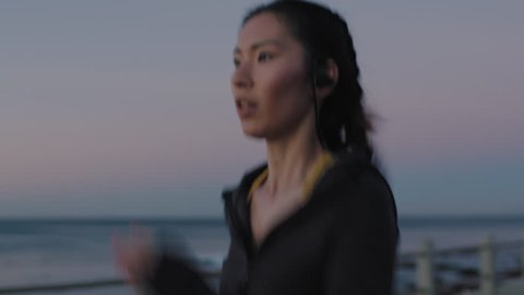attractive young asian woman running training cardio jogging enjoying fitness workout lifestyle on seaside at sunset