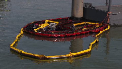 used oil spill containment boom floating on water surface