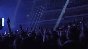 Unidentified fans dancing and shooting mobile videos at the concert in crowded music hall