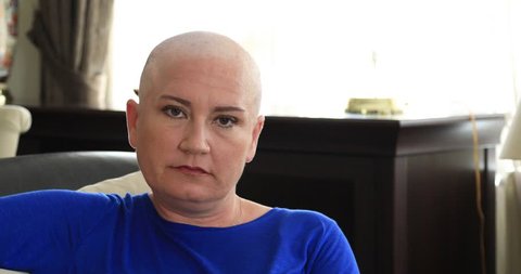 Portrait of a bald woman cancer patient smiling to camera