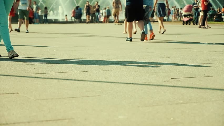 crowd of people walking on sunny streets