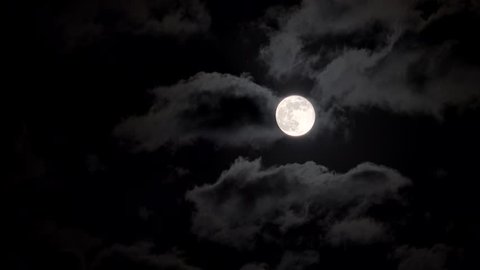 Full moon in a night cloudy sky.