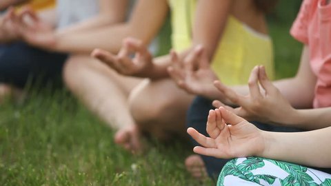 Group of children sitting in yoga pose in the Park