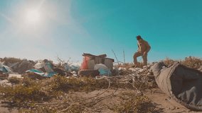 dirty homeless man at the dump slow motion video. homeless lifestyle roofless person looking for food in a dump. refugee homeless illegal immigration poverty concept