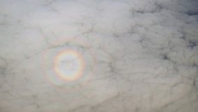 Solar halo effect in the low altitude clouds. as seen from the window of a commercial passenger plane. high above.