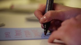 Close up of a woman writer hand writing in a notebook at home . RAW video record. 4K