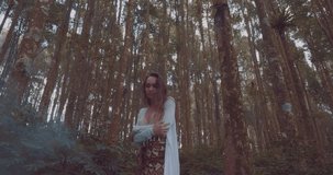 Beautiful brunette woman walking in hazy tropical mountain forest - video in slow motion