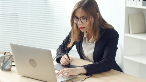 Woman designer working in office with graphic tablet