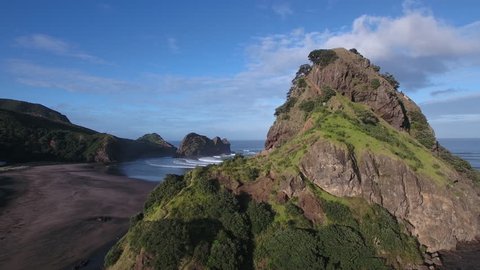Aerial view of Lion Rock and large surf waves at Piha Beach, Auckland, New Zealand