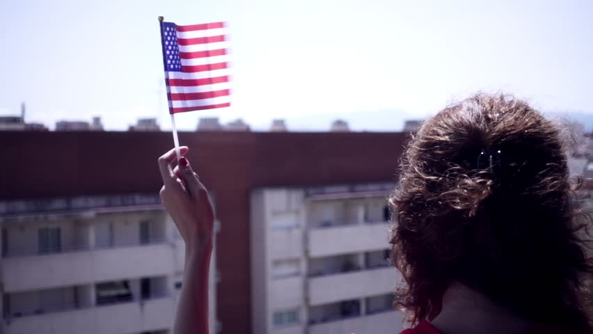 Red dressed woman waving USA national flag hand and celebrating a patriotic and american national holiday like 4th of July, Flag day, national day or memorial day. Royalty-Free Stock Footage #1012990550