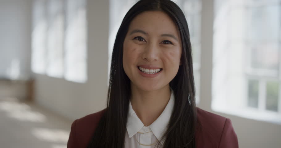 Portrait of young friendly asian woman smiling looking at camera wearing formal suit happy female cute face in apartment background real people series | Shutterstock HD Video #1012991828