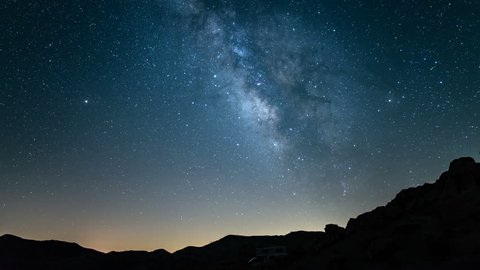 Milky Way to sunrise time lapse RV camper in rocky canyon Mojave Desert