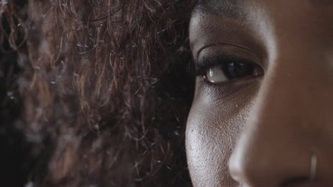 close up of african american woman eye blinking looking serious at camera macro shot