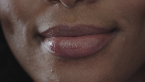 close up of african american woman glossy lips smiling happy beautiful perfect skin macro shot