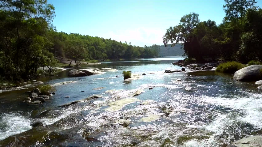 Aerial view river rapids sparkle and stream washing stones against wonderful green forest