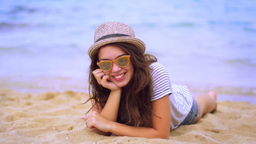 Девушка улыбка пляж в очках. Девушка мило улыбается на пляже. Girl laying Sand. Resting Beach face.