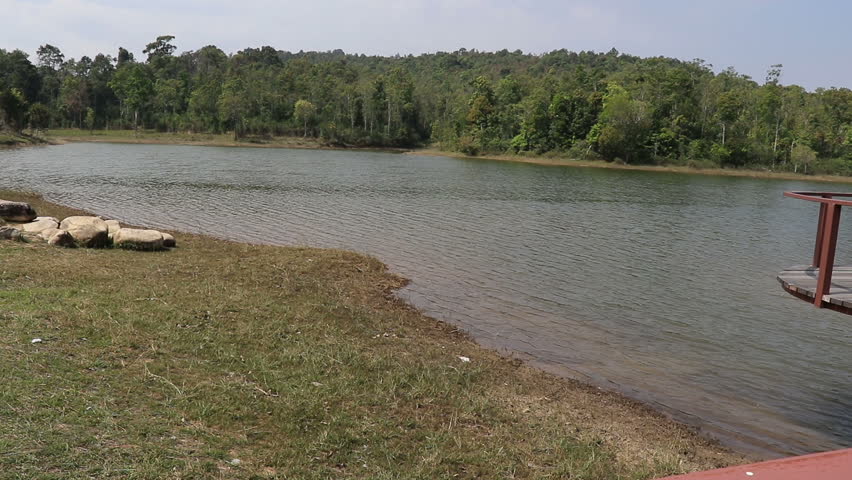 a man asian backpack standing Wooden bridge in the park and walking on a long hanging bridge .