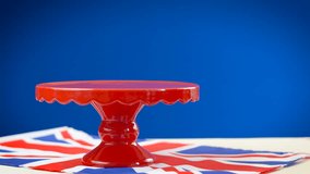 Time lapse of red white and blue theme cupcakes and cake stand with UK Union Jack flags for Queen's Birthday weekend celebration or Great Britain party food.