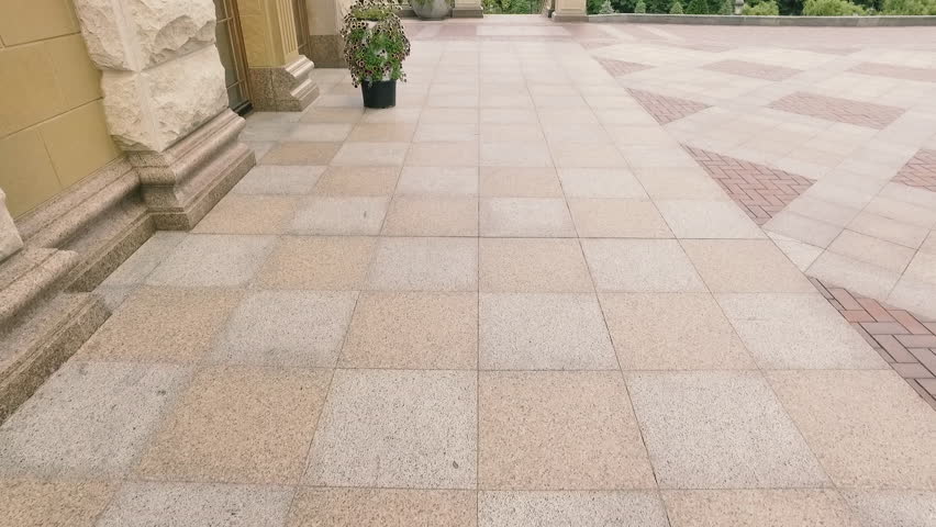 The floor is made of a decorative stone near the building in a public park. Exterior of the house. Architecture and buildings