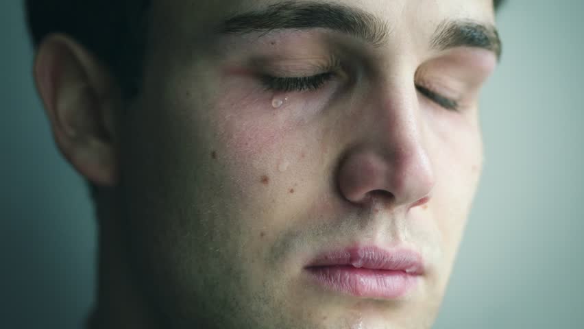Close up portrait of depressed young beautiful man cries.Depression, malaise, sadness