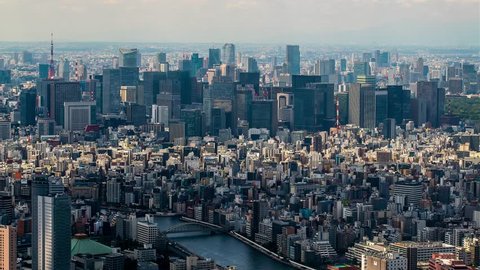 Tokyo Aerial View. Time-lapse panorama from high point. Clouds over the city cast shadows.