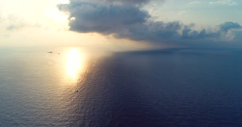 539  Aerial 4k cinematic view of fishing boat crossing calm sea during sunrise , dramatic clouds at horizon, beautiful scenery of tranquil seascape . Video de stock