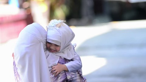 Concept is Happy Indonesian Muslim family,Daughter rushes into her lovely mother's arms and gives her a big hug. 