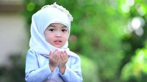 Muslim kid girl praying Dua during Ramadan period. The concept is Islam,Dua,religion,worship and sin.