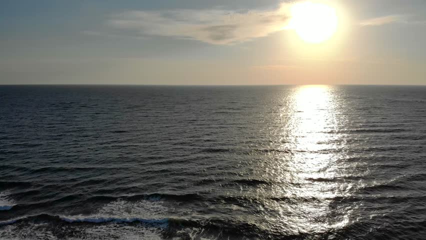 Aerial drone lateral motion footage morning sunrise over ocean. 4k