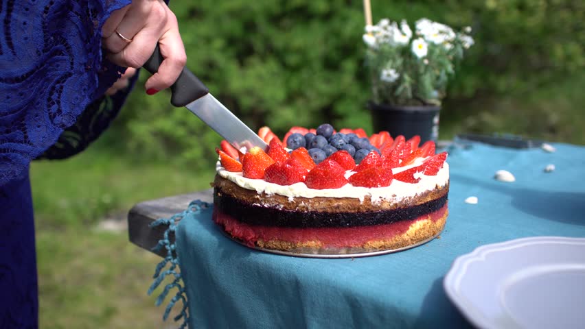 Slicing beautiful cake with fruits