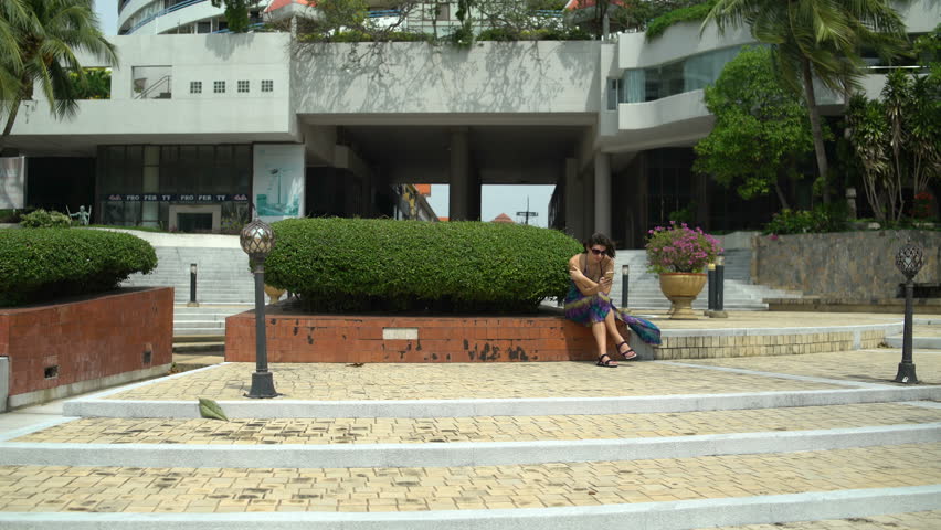 Woman sitting on the steps in front of the hotel