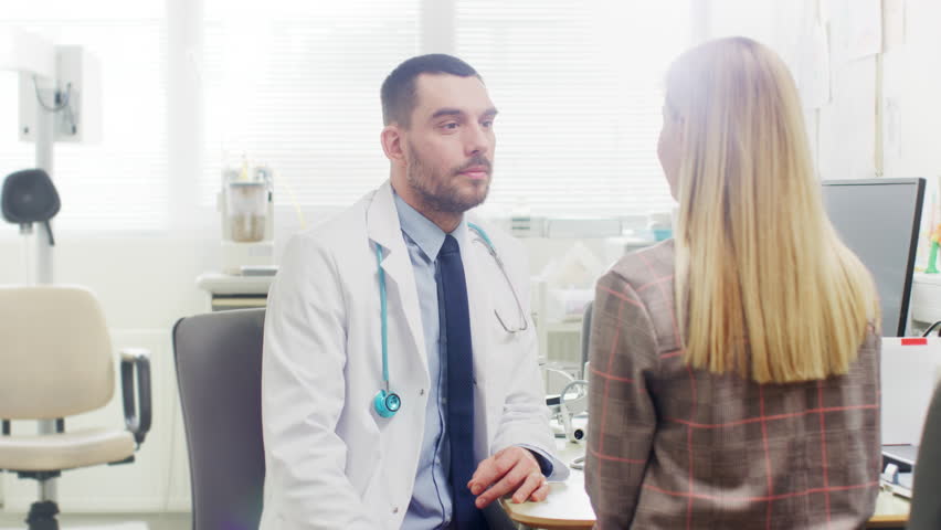 In Medical Office Concerned Doctor Talks with a Beautiful Blonde Woman. Health Care Professional Consultation in the Bright Modern Office. Shot on RED EPIC-W 8K Helium Cinema Camera. Royalty-Free Stock Footage #1013081894