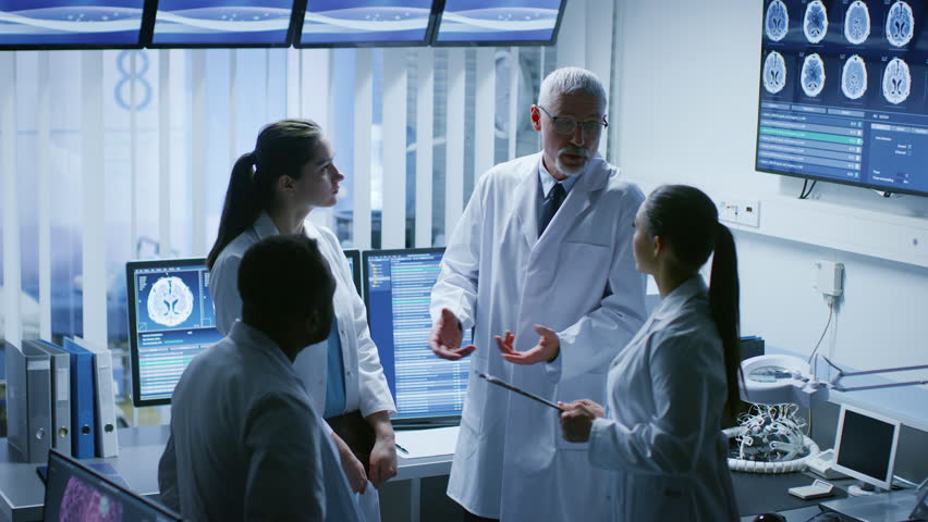 Meeting of the Team of Medical Scientists in the Brain Research Laboratory. Neurologists / Neuroscientists Having Analytical Discussion. Shot on RED EPIC-W 8K Helium Cinema Camera.