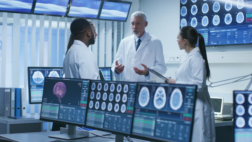 Meeting of the Team of Medical Scientists in the Brain Research Laboratory. Neurologists / Neuroscientists Having Heated Discussion Surrounded by Monitors Showing CT, MRI Scans. Shot on RED EPIC-W 8K.