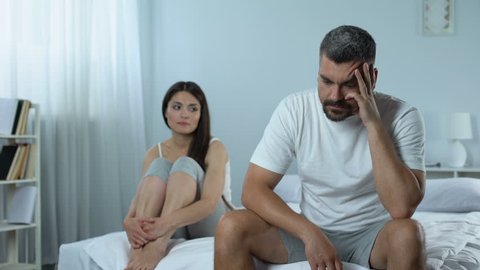 Man suffering problems with masculine health, wife supporting him, impotence