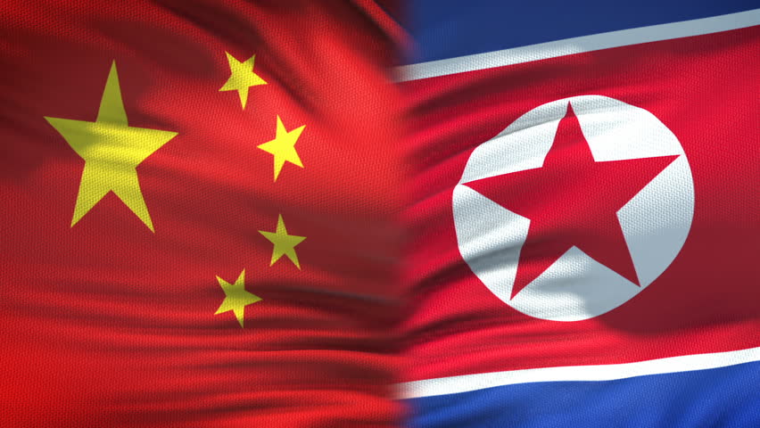China and North Korea handshake international friendship summit, flag background