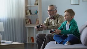 Grandpa playing video game with grandson, winning, communication with young