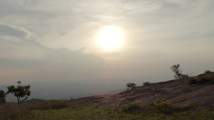 Mountain bikers cycling up a steep rocky hill against the sunset