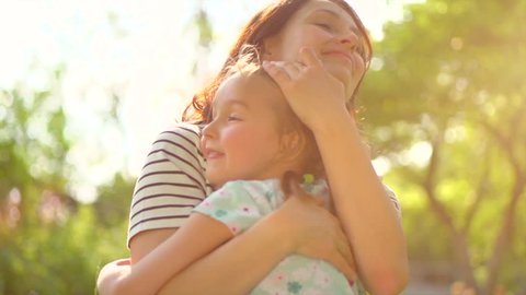 Beautiful Mother And her little daughter outdoors. Nature. Beauty Mum and her Child playing in Park together. Kissing and hugging happy family. Happy Mother's Day Joy. Mom and Baby. Slow motion 4K