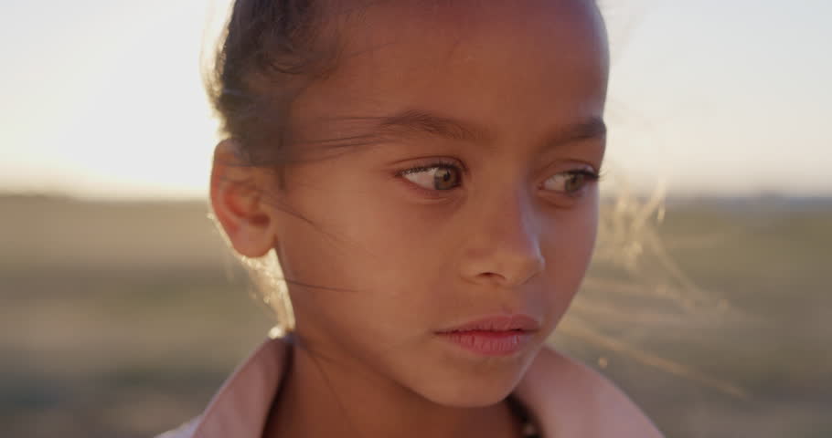 close up portrait young little mixed race girl looking serious contemplative kid on sunny park sunset real people series Royalty-Free Stock Footage #1013096600
