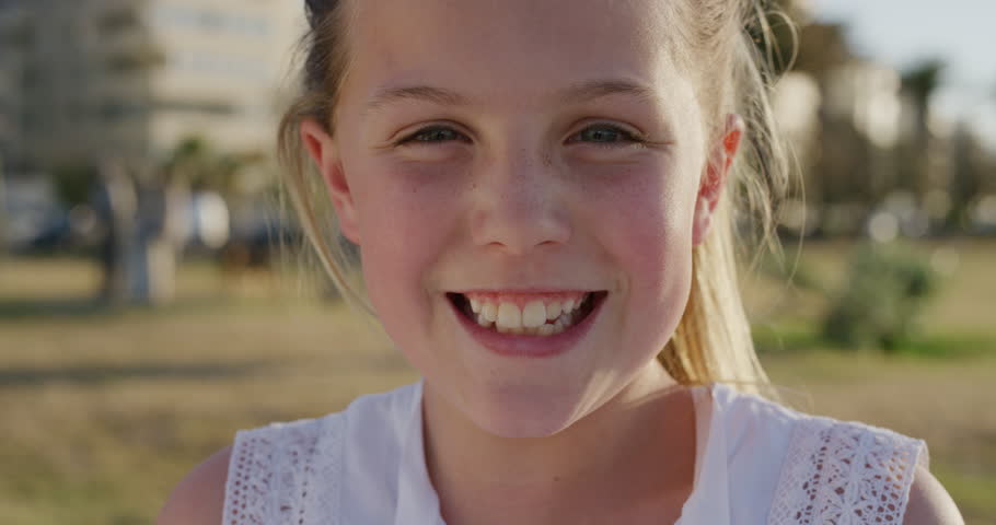 Close up portrait beautiful little girl laughing cheerful enjoying relaxed summer vacation day on warm sunset urban park wind blowing hair slow motion | Shutterstock HD Video #1013096663