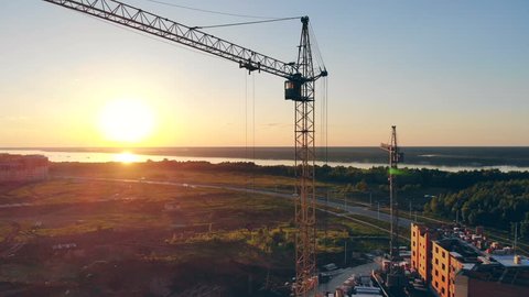 Construction crane on a sunset background. Real estate concept.
