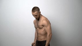 Slow motion video of a shirtless muscular man training with Resistance Band