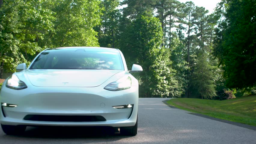 RALEIGH - JUNE 26, 2018: New all electric Tesla Model 3 driving down the road. | Shutterstock HD Video #1013108249