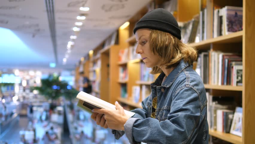 Woman Reading A Book In Library. | Shutterstock HD Video #1013109227