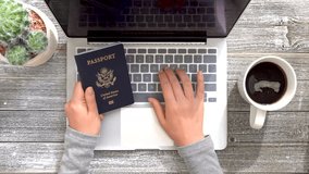 Person with an American passport typing information into a laptop